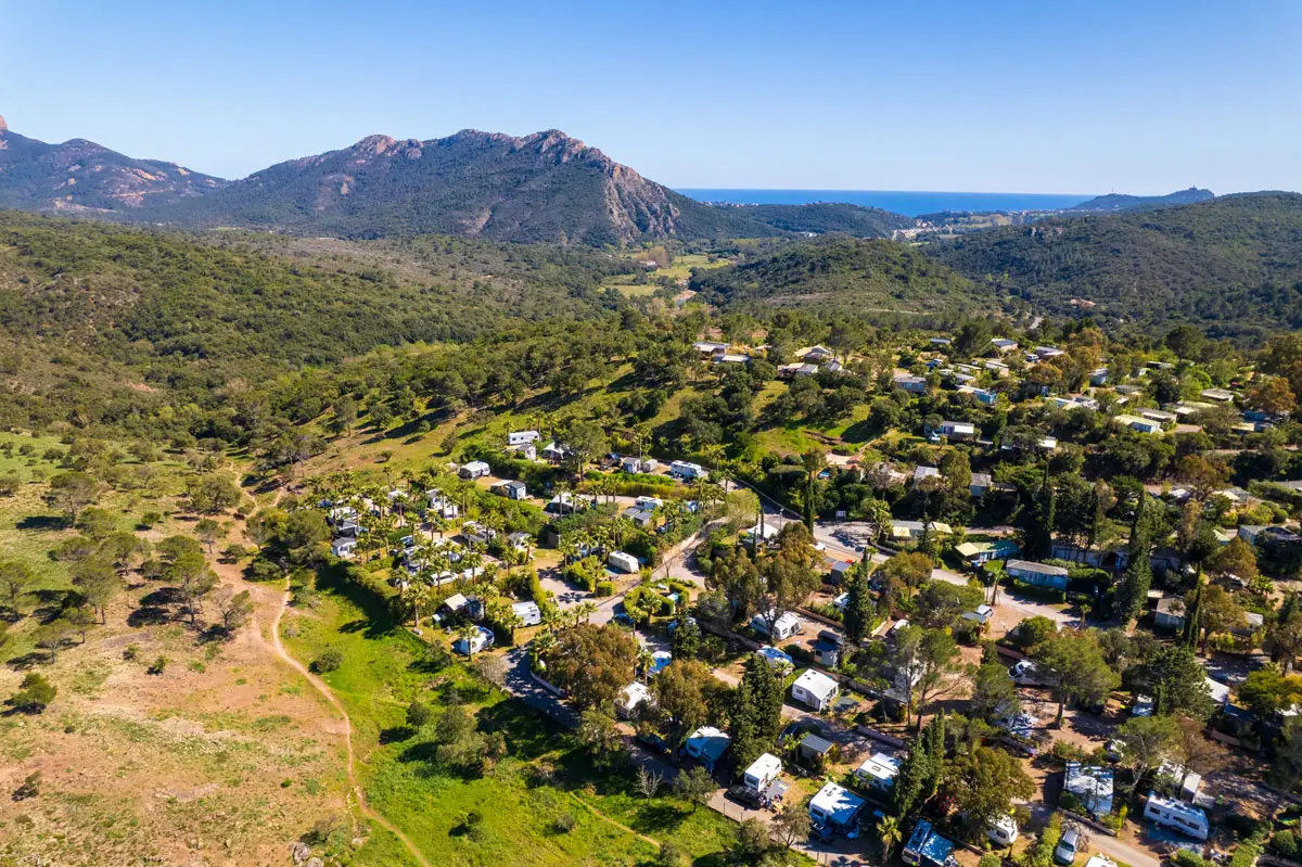 Luchtfoto van het domein van Esterel Caravaning in Agay: kampeerplaatsen onder de pijnbomen, het Esterel-massief en de zee aan de horizon