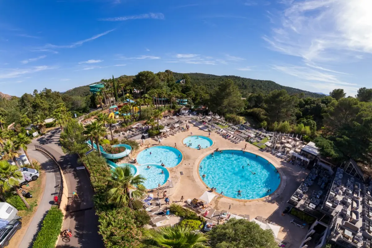 Luchtfoto van het waterpark van Esterel Caravaning, met zwembaden, glijbanen en palmbomen